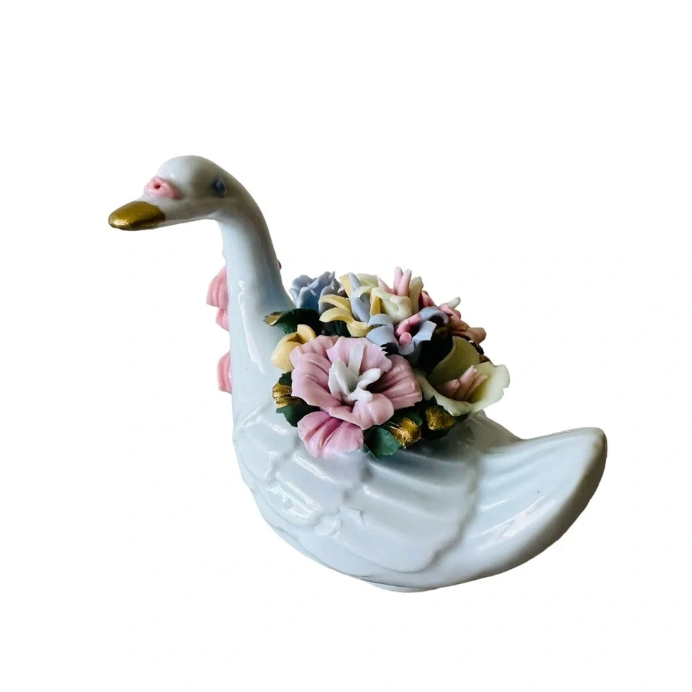 Beautiful little porcelain swan figurine with a back full of flowers!